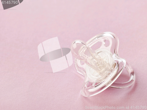 Image of transparent pacifier on pink background