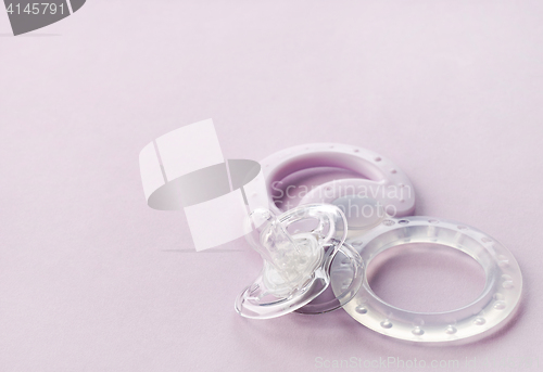 Image of transparent pacifier on pink background