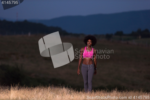 Image of Young African american woman jogging in nature