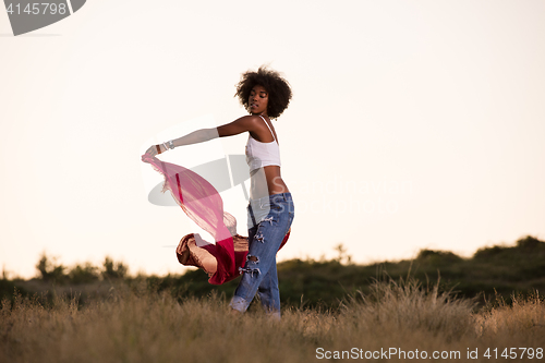 Image of black girl dances outdoors in a meadow