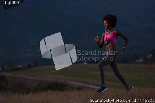 Image of Young African american woman jogging in nature