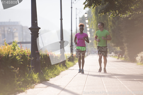 Image of young multiethnic couple jogging in the city
