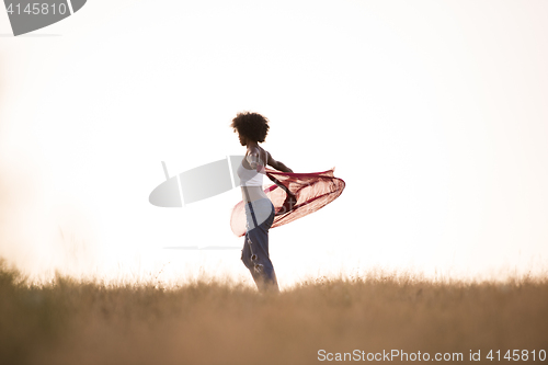 Image of black girl dances outdoors in a meadow