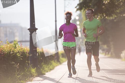 Image of young multiethnic couple jogging in the city