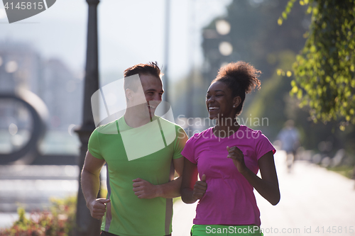 Image of young multiethnic couple jogging in the city