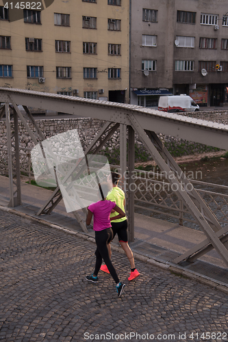 Image of young multiethnic couple jogging in the city