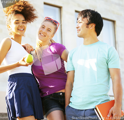 Image of cute group of teenages at the building of university with books huggings, back to school