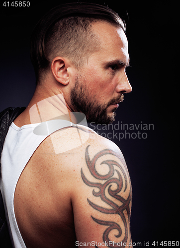 Image of A man with tattooes on his arms. Silhouette of muscular body. caucasian brutal hipster guy with modern haircut, looking like criminal