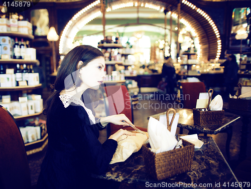 Image of young elegant brunette woman in cafe drinking coffee, luxury int