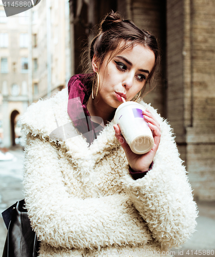 Image of young pretty stylish teenage girl outside on city street fancy f