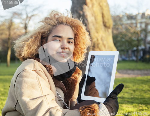 Image of young cute blond african american girl student holding tablet and smiling, lifestyle people concept