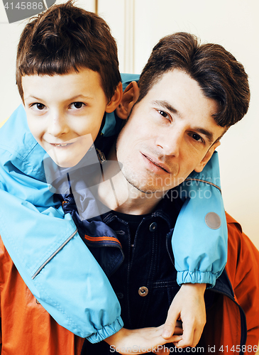 Image of young handsome father with his son fooling around at home, lifes