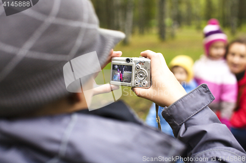 Image of little offspring shooting his family in park outside, lifestyle people concept