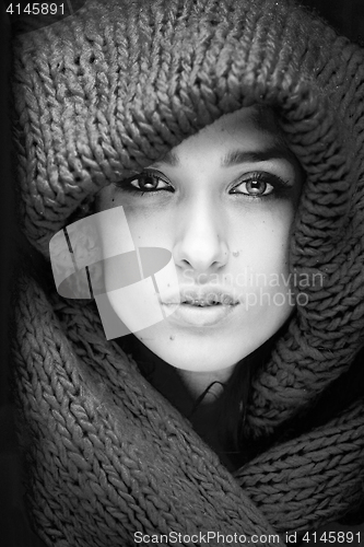 Image of young pretty woman in sweater and scarf all over her face black and white