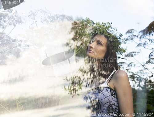 Image of portrait of pretty young woman in field with high grass enjoing nature, double exposure concept