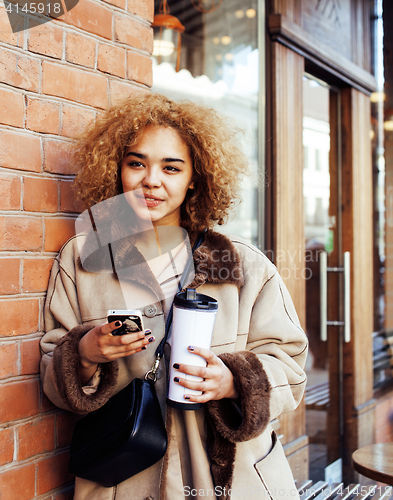 Image of young pretty african american women drinking coffee outside in cafe, modern business woman lifestyle concept