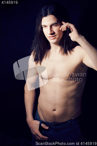 Image of handsome young man with long hair naked torso on black backgroun