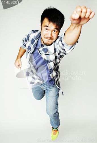 Image of young pretty asian man jumping cheerful against white background, lifestyle people concept