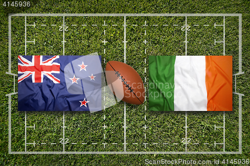 Image of New Zealand vs. Ireland flags on rugby field
