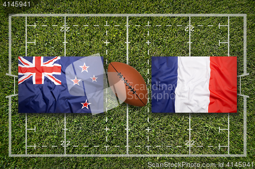 Image of New Zealand vs. France flags on rugby field