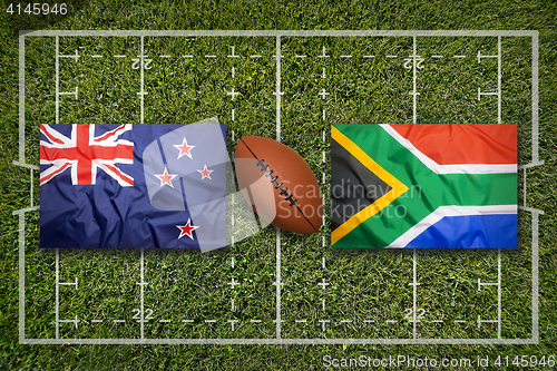 Image of New Zealand vs. South Africa flags on rugby field