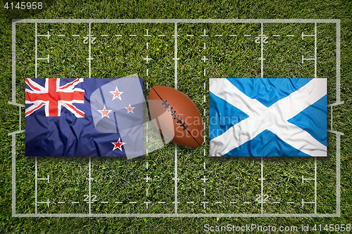 Image of New Zealand vs. Scotland flags on rugby field