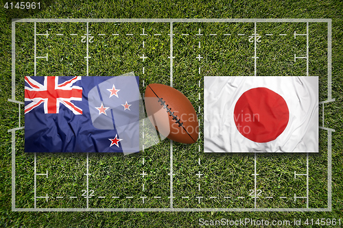 Image of New Zealand vs. Japan flags on rugby field