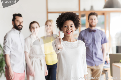 Image of woman showing thumbs up over creative office team