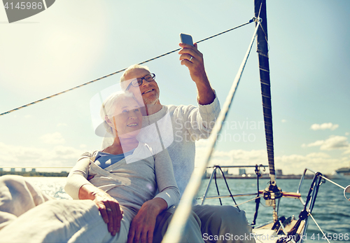 Image of senior couple taking selfie by smartphone on yacht