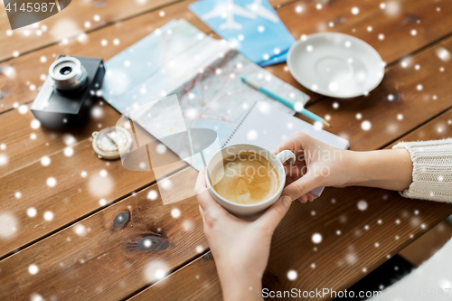 Image of close up of hands with coffee cup and travel stuff