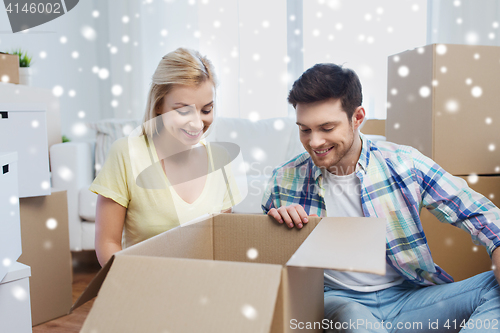 Image of smiling couple with big boxes moving to new home