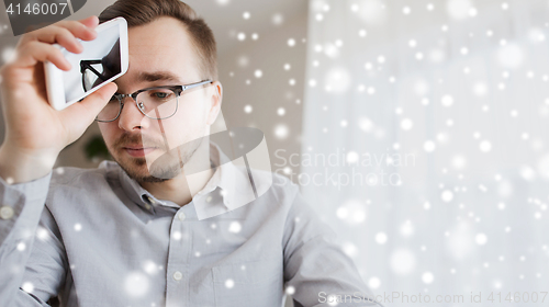 Image of sad man with smartphone at home over snow