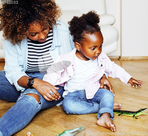 Image of adorable sweet young afro-american mother with cute little daughter playing toys at home, lifestyle people concept