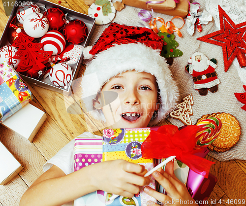 Image of little cute boy with Christmas gifts at home. close up emotional