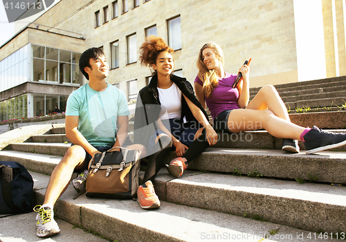 Image of cute group of teenages at the building of university with books 