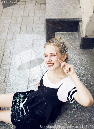 Image of young pretty party girl smiling covered with glitter tinsel, fas