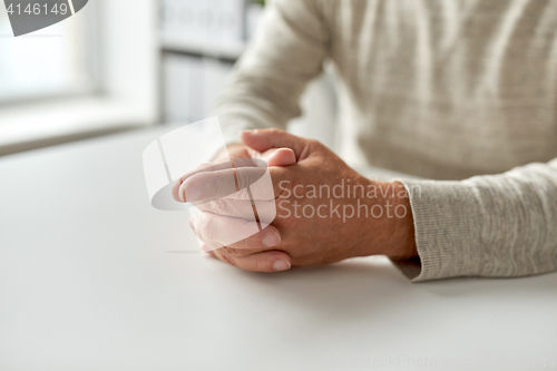 Image of close up of senior man hands on table