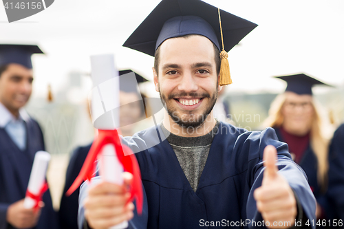 Image of bachelor showing diploma and thumbs up