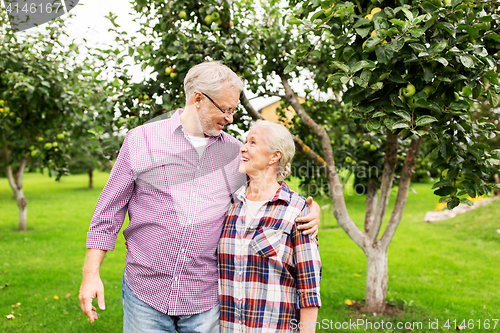 Image of happy senior couple hugging at summer garden