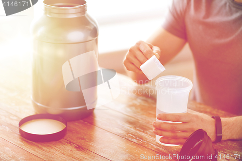 Image of close up of man with protein shake bottle and jar