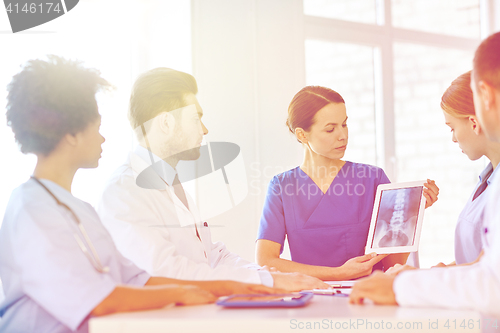 Image of group of doctors with x-ray on tablet pc at clinic