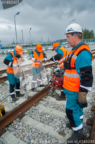 Image of Railway workers repairing rail in rain