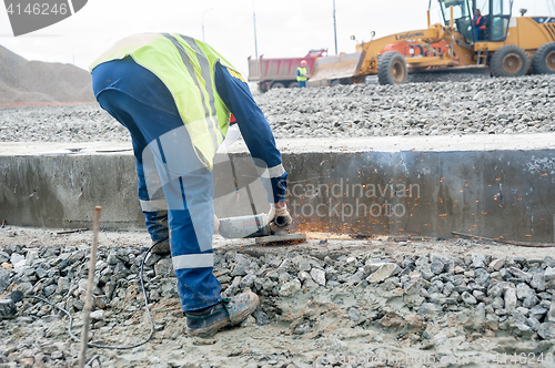 Image of Worker cuts off surplus of fittings on new plant