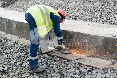 Image of Worker cuts off surplus of fittings on new plant