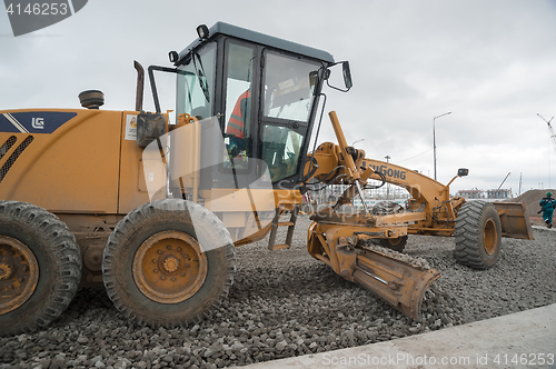 Image of Grader leveling gravel on construction site