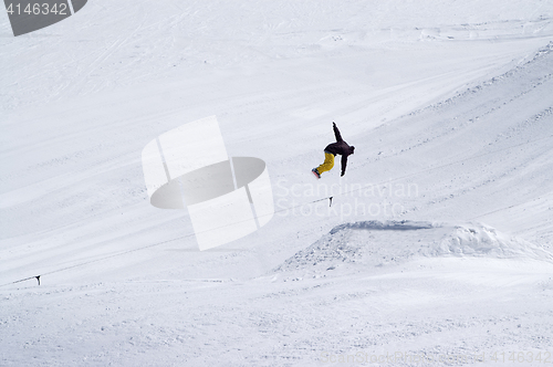 Image of Snowboarder jumping in snow park at ski resort on sun winter day