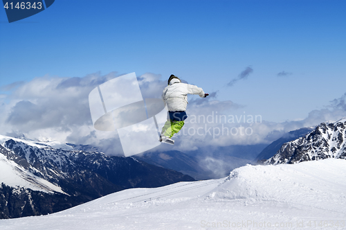 Image of Snowboarder jumping in terrain park at ski resort on sun winter 