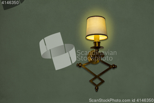 Image of Old wall lamp made of metal with shade from canvas
