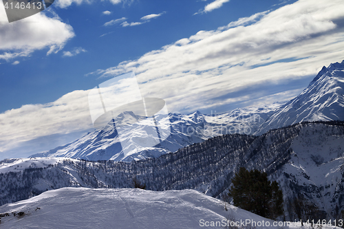 Image of Off-piste slope and snow winter mountains in sun evening