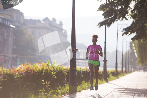 Image of african american woman jogging in the city